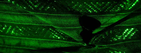 Büyüleyici parıltılı desenli koyu yeşil kumaş. Karmaşık tasarımlar aydınlatmayla vurgulanır, ona soyut ve lüks bir his verir, parlak dokularla vurgulanır..