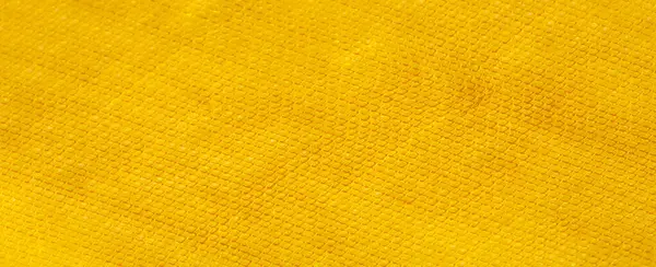 Görüntü. Bu sarı kumaşın pürüzsüz dokusu nazik kıvrımlar ve merkezi bir bükülme ile vurgulanarak yüzeyinde görsel bir ışık ve gölge ritmi yaratır..