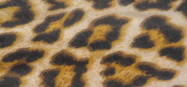 Görüntü, canlı leopar desenli kumaş, sarı, siyah ve bej renklerin karışımı. Kumaş kırışık ve dokulu, desene derinlik ve boyut ekliyor..