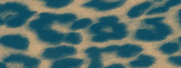 Görüntü, yumuşak kıvrımlara sarılı çarpıcı bir leopar desenli kumaş, daha hafif bir arka planda koyu lekeler, görsel olarak çekici ve desenli bir tasarım yaratıyor moda ve dekor için mükemmel..