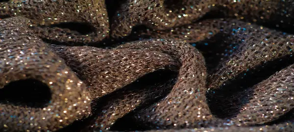 Parlak röfleli koyu renk kumaş bulanıklığı, hafif bir parıltı etkisi. Doku yumuşak ama yapılandırılmış görünüyor, küçük ışık zerreleri maddeye boyut ve derinlik katıyor..