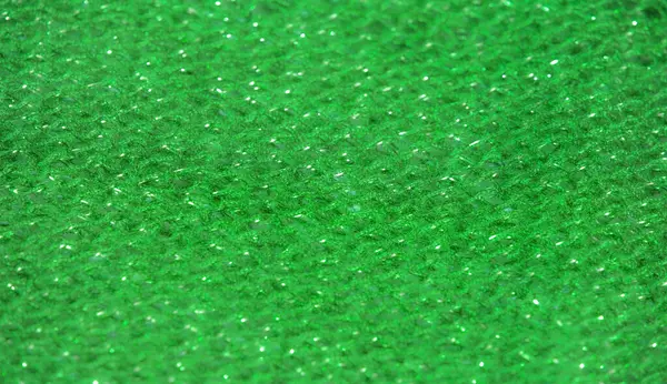 Parıldayan ipliklerle örülmüş koyu yeşil kumaş ışığı yakalıyor. Kumaşın zengin dokusu ve kıvrımları lüks bir derinlik ekler, moda ve tasarım uygulamaları için mükemmeldir.