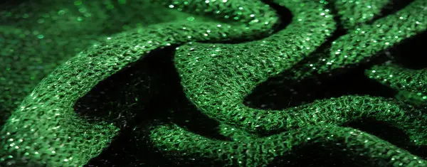 Bulanık yumuşak, zümrüt yeşili kumaş parıldayan dokular ve karmaşık dokuma detaylarıyla, canlı ve parlak bir görünüm sunuyor. Kumaşın kıvrımları derinlik yaratır, parlayan etkiyi arttırır.