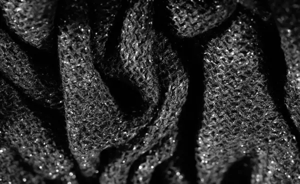 Işıl ışıl yüzeyi olan parlak siyah kumaşın bulanık görüntüsü. Karmaşık doku ve parlak iplikler moda veya tasarım için mükemmel, zarif ve lüks bir his yaratır..