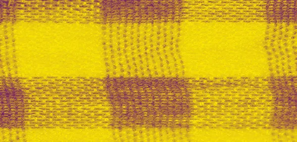 Yumuşak sarı kumaşın bulanık kıvrımları, akışkan dokular ve kareli bir görünüm ile soyut bir model oluşturur. Yakın plan, sıcak ve davetkar bir görsel efekt oluşturarak, karmaşık dokumayı vurgular.