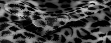 Süzülen çizgiler ve şekillerle siyah beyaz desenli bulanık yumuşak kumaş. Şeffaf doku zarafet ekler, koyu motifleri daha açık arkaplan ile harmanlayarak derinliği arttırır.