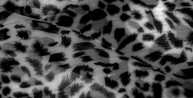 Görüntü. Yumuşak, karmaşık desenli gri tonda ve akışkan siyah tasarımlı kumaş. Işık yansımaları zengin bir doku yaratır, arka plan, tekstil veya yaratıcı projeler için mükemmeldir..