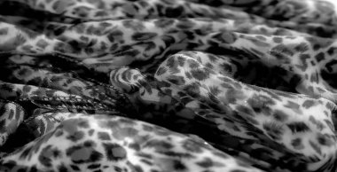 Şeffaf bir arkaplanda koyu siyah desenli hassas kumaşın bulanık görüntüsü. Organik tasarım ve katıksız doku yumuşak ve modern bir his veriyor.