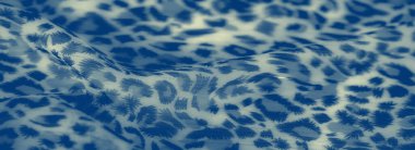 Bulanık, soyut desenleri ve yumuşak kıvrımları olan mavi renkli kumaş. Karmaşık doku ve akışkan tasarım, arka planlar için mükemmel, görsel olarak çekici bir yüzey yaratır..