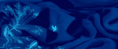 Görüntü. Yumuşak kıvrımlı ve gölgeli koyu mavi tekstil. Huzurlu, lüks bir ortam yaratıyor. Soyut arka planlar, tekstil desenleri ve zarif görseller için uygun..