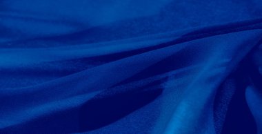 Görüntü. Yumuşak gölgeli mavi kumaşın yumuşak akışını ve derinliğini yakalayan bu resim, tekstil arka planı ve dekor teması için mükemmel dinamik bir görüntü sağlıyor..
