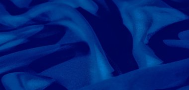 Görüntü. Mavi kumaşın soyut bir yakın çekimi, karmaşık kıvrımlar ve ışık oyunlarını, zarafet ve çok yönlülüğü, modern arka planlar ve tekstil sanatı için uygunluğu gösteriyor.