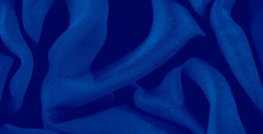 Görüntü. Hassas katları olan koyu mavi bir kumaş, derinlik ve zarafet katan gölgeler, yüksek kaliteli arka planlar ve tekstil tasarımları için mükemmel bir doku yaratıyor..