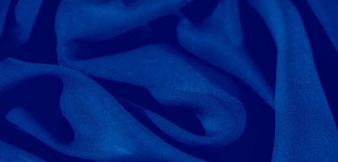 Görüntü. Hassas katları olan koyu mavi bir kumaş, derinlik ve zarafet katan gölgeler, yüksek kaliteli arka planlar ve tekstil tasarımları için mükemmel bir doku yaratıyor..