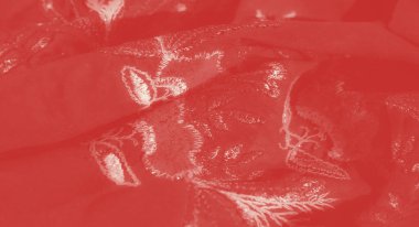 Görüntü. Karmaşık beyaz işlemeli yumuşak kırmızı kumaş zarif, akışkan bir doku oluşturur, zarafet ve lüks yayar. İşlemeli çiçek ve yaprak motifleri kumaşa derinlik ve incelik ekler.,