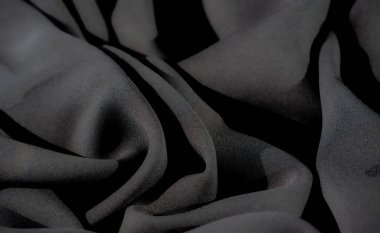 Bulanık, dalgalı siyah kumaş pürüzsüz, gölgeli hatlar ve derin tonlarda ışık ve karanlık elementlerin karışımını sergiler. İnce dokusu ve ince eğimleri sofistike ve sakinleştirici bir atmosferi çağrıştırıyor..
