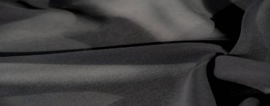 Bulanık siyah kumaş yumuşak, koyu kıvrımlı ve ince gölgeli akar. Zarafet ve incelik katar. Lüks arka planlar ya da moda dokuları için ideal..