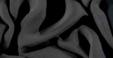 Bulanık, yumuşak siyah kumaş perdeler yumuşak, gölgeli kıvrımları var. Bu doku, hem karmaşık hem de gizemli görünmesini sağlayan zengin bir derinlik ve ince bir ışık etkileşimi yaratır.