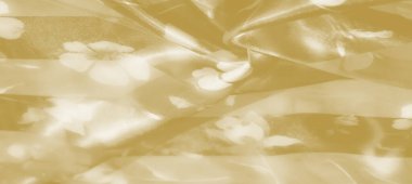 Yumuşak sarı kumaşın bulanık, narin kıvrımları, soluk çiçek desenlerini ortaya çıkarıyor. Yumuşak, akışkan dokusu sıcak, rahat bir estetik yaratıyor. Bu da onu zarif ve dingin arka planlar için ideal yapıyor..