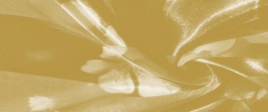 Nazikçe akan kıvrımlı bulanık sarı kumaş, narin bir parıltıda ışığı yakalıyor. Yumuşak dokusu ve sıcak tonu lüks ve sofistike bir görüntü yayar..