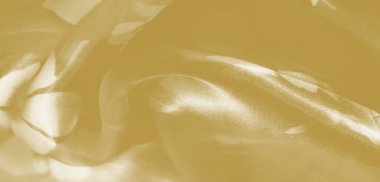 Sarı kumaş bulanık, narin kıvrımlı kıvrımlar ve saten bir kaplama. Karmaşık dokusu ve yumuşak gölgeleri sıcaklığı ve lüksü çağrıştırıyor. Huzurlu bir arka plan için mükemmel..