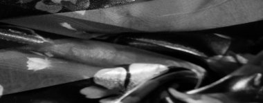 Yumuşak çiçek desenli gri tonlu kumaş. Şeffaf ve mat çizgiler sırayla, dağınık çiçekli katmanlı bir görünüm yaratarak narin, dokulu bir his yaratır.