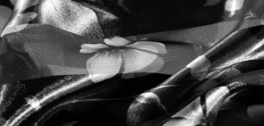 Gri tonlu kumaş üzerindeki yumuşak çiçek motifleri, düz ve düz çizgili kısımlarla bulanık. Katmanlı efekt tasarıma derinlik ve boyut getirir, dekoratif uygulamalar için idealdir..