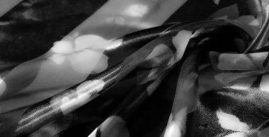Çiçek desenleriyle süslenmiş tek renkli kumaş pürüzsüz, değişken opak ve katıksız çizgilerle narin ışık ve gölge etkileşimiyle zarif bir estetik yaratıyor..