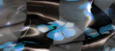 Bulanık. Saf siyah kumaş ve canlı mavi çiçek aksanlarının zarif bir karışımı. Her kıvrımında yumuşak bir parıltı olan ahenkli ve ruhani bir desen oluşturuyor..