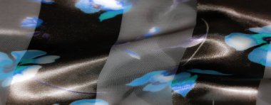 Bulanık siyah ve saf katmanlar ince bir arkaplan oluşturur, mavi ve mor çiçekli tasarımlar hassas ama cesur bir kontrastlık ekler, derinlik ve karmaşıklık getirir..