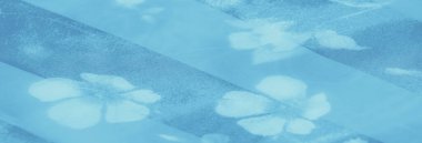 Şeffaf mavi kumaş, yumuşak çiçek aksanları ve akışkan kıvrımları, dingin ve sakin cazibesini arttırıyor, zarif temalar için yumuşak odaklı arka plan olarak ideal..