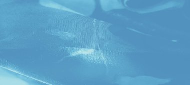 Katmanlı çiçek dokuları ve nazik kıvrımlarıyla pürüzsüz, açık mavi bir kumaşın bulanıklığı zarafeti ve durgunluğu aktaran yumuşak odaklı bir görsel yaratıyor..