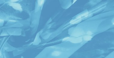 Mavi kumaştan bulanık, narin çiçekli ipuçları ve yumuşak, ışıl ışıl parlak ışıklar yumuşak kıvrımlarında huzurlu ve rüya gibi bir ortam yaratıyor..