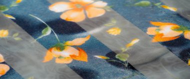 Şeffaf ve opak çizgileri olan zarif çiçek kumaşı parlak turuncu ve sarı çiçekleri sergiliyor. Işıldayan doku ve yumuşak kıvrımlar tasarıma lüks bir dokunuş ekler..