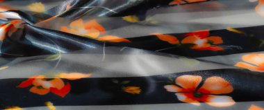 Siyah ve şeffaf çizgilere karşı canlı turuncu ve sarı çiçekli desenli bir çiçek kumaşı. Kumaşlar pürüzsüz katlar boyut ekler