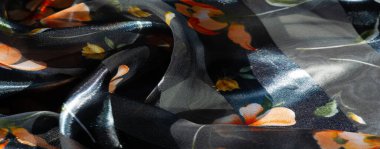 Mavi arka planı olan, turuncu ve sarı renkli canlı çiçek desenleriyle süslenmiş, akışkan saf kumaş bulanıklığı. Yumuşak kıvrımlar ve parlaklık lüks bir estetik yaratır..