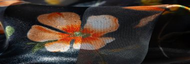 Turuncu ve sarı çiçek elementleriyle süslenmiş parlak, şeffaflık ve dokuyu harmanlayan saf kumaş bulanıklığı. Yumuşak ışıklandırma onun lüks çekiciliğini arttırır.