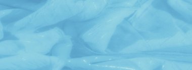 Pastel mavi kumaş bulanıklığı ışık katlarında narin bir parıltı sergiliyor, tekstile yumuşak ve ruhani bir kalite katıyor. Nazik ve aydınlık, yaratıcı arka planlar için ideal..