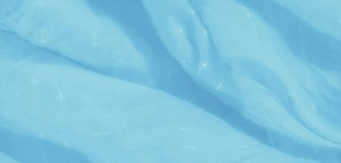 Bulanık Mavili kumaş yumuşak kıvrımları ince, parlak aksanlarıyla sergiliyor. Havadar madde, hafif ışıklandırma altında hafif bir parıltıyla rahatlatıcı bir estetik sunuyor..