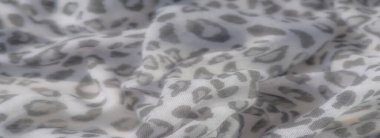 Yumuşak, akışkan kıvrımlı, soyut gri desenlerle süslenmiş hassas beyaz kumaş. Yumuşak dokusu ve sakin tonları sofistike ve sakin bir atmosfer yaratır..