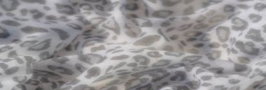 Yumuşak desenli, gri desenli beyaz kumaş bu yakın planda zarif bir görünüm yaratıyor. İnce kıvrımlar ve pürüzsüz tasarım, sakin ve sofistike bir hissi çağrıştırıyor..