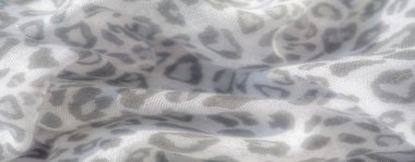 Bulanık yumuşak, ince gri tonlu leopar desenleriyle süslenmiş narin bir dokusu olan akıcı beyaz kumaş. Kumaşlar nazikçe katlanır ve dokular rüya gibi, ruhani bir estetik yaratır.,