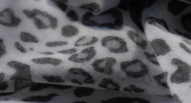 Hafif gri leopar desenli yumuşak, akıcı beyaz kumaş üzerinde bulanık bir etki. Doku ve hassas detaylar tekstil tasarımı veya dekoratif kavramlar için mükemmel sakin ve soyut bir arkaplan oluşturur..