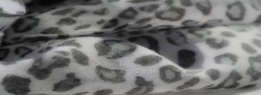 Bulanık efekt, hafif kumaş üzerindeki gri ve beyaz leopar benzeri izi vurgular, yumuşaklık ve dokuyu vurgular, dekoratif veya moda esinlenilmiş arka planlar için idealdir..