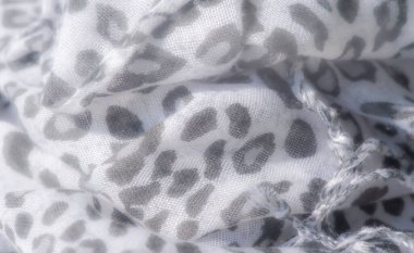 Beyaz arka planda gri leopar lekeli hafif bir kumaşın bulanık görüntüsü. Yumuşak kıvrımlar ve doku minimalist ama zarif bir görsel etki yaratır..