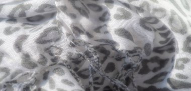 Bulanık etki, beyaz kumaş üzerindeki gri leopar izine yumuşaklık katar, moda veya iç tasarım kavramları için uygun, eşsiz bir doku ve tasarım karışımı yaratır..