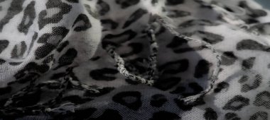 Görüntü. Beyaz üzerine gri leopar desenli yumuşak desenli kumaş. Yumuşak bir akışla katlanmış. Moda, tekstil ve soyut tasarım için ideal..