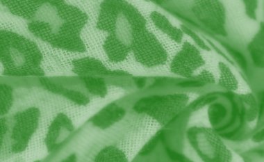 Bulanık yeşil kumaş, soyut bir leopar desenine sahip. Akan kıvrımlar bu büyüleyici tekstil tasarımına biraz incelik ve incelik katıyor.