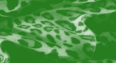 Görüntü, hayvan izlerine benzeyen detaylı desenlere sahip zengin yeşil bir kumaş. Derinlik katar, moda, döşeme ya da sanatsal projeler için ideal hale getirir..
