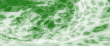 Bulanık, benzersiz leopar desenli yeşil bir kumaşın makro görüntüsü. Karmaşık dokusuna ve nazik dokusuna odaklanıyor. Yumuşak kıvrımlar bu dinamik tekstile biraz zarafet katıyor..